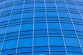 The bright blue sky is reflected in the windows of a modern glass building. Abstract fragment of a modern building. Royalty Free Stock Photo