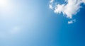 Bright Blue Sky with a Single Fluffy White Cloud and Sun Flare clouds Royalty Free Stock Photo