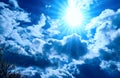 Bright blue Solar sky background with white clouds and sun. Royalty Free Stock Photo