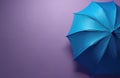 Bright blue umbrella open on a plain purple background. Minimalist object detail shows fabric texture and structure. Useful for Royalty Free Stock Photo