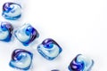 Bright blue washing pods and capsules with liquid detergent for machine laundry on white clothing background with copy space. Royalty Free Stock Photo