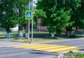 Bright blue and yellow pedestrian crosswalk sign on a town street with traffic warning. Royalty Free Stock Photo