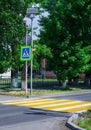 Bright blue and yellow pedestrian crosswalk sign on a town street with traffic warning. Royalty Free Stock Photo