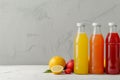Bright bottles with citrus juices on background Royalty Free Stock Photo