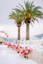 Bright bouquets of flowers stand along rows of white chairs in front of the wedding arch Royalty Free Stock Photo