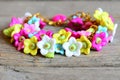 Bright bracelet isolated on old wooden background. Bracelet made of colorful plastic flowers, leaves and beads. Accessory Royalty Free Stock Photo