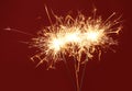 Bright burning sparklers on red background, closeup Royalty Free Stock Photo