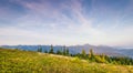 Bright Carpathian landscape in the morning light with beautiful green grass and blue sky. Royalty Free Stock Photo