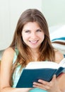 Bright caucasian woman reading a book on the sofa