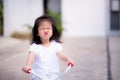 A bright cheerful Asian kid girl aged 3 or 4 years old is riding a tricycle and she makes a cute wrap mouth duck face Royalty Free Stock Photo