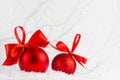 Bright christmas background - two elegant glossy glitter red balls with satin ribbon closeup in decorative fairy white winter. Royalty Free Stock Photo