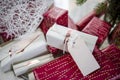 Bright Christmas decorations and gifts in holiday wrappers with tags and ribbon folded under the Christmas tree Royalty Free Stock Photo