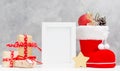 Bright christmas mock up with photo frame: festive gift boxes, toys, and fir-cones in red santa`s boot New year concept