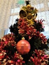 Bright christmas tree with pink bauble, tinsel and bells