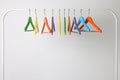 Bright clothes hangers on metal rack against light background Royalty Free Stock Photo