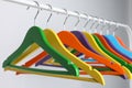 Bright clothes hangers on metal rack against light background, closeup Royalty Free Stock Photo