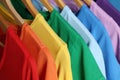 Bright clothes on wooden hangers. Rainbow colors