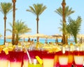 Bright cocktails in background of tropical resort with palm trees, sea and people. Holiday concept