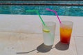 Bright cocktails with straws close-up by the pool in the hotel.