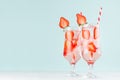 Bright cold strawberry cocktail with ripe red slices berry and sparkling water, ice cubes, red striped straw in misted glass. Royalty Free Stock Photo