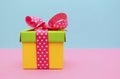 Bright color gift box on pink and blue background.