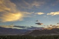 A bright colored clouds in the dark blue sky during sunset over the city in the mountains Royalty Free Stock Photo