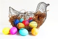 Bright colored Easter eggs in a wire chicken basket.