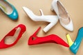 Bright colored high heel women`s shoes on a solid beige background. Flat lay top view Royalty Free Stock Photo