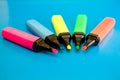 Bright colored markers for highlighting text on a blue background, colored felt-tip pens for drawing.