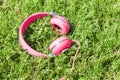 Bright colored pink headphones on green sward Royalty Free Stock Photo