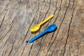 bright colored plastic spoons on wooden table blue and yellow spoon Royalty Free Stock Photo