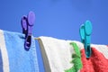 Bright colored towels pegged to a washing line against a clear blue sky Royalty Free Stock Photo