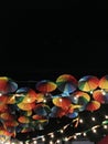 Bright colored umbrellas, painted in all the primary colors of the palette, against the background of the dark night sky