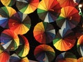 Bright colored umbrellas, painted in all the primary colors of the palette, against the background of the dark night sky