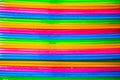 Bright colored vertical stripes of trays stacked in a pile, pink, green, yellow, blue colors. Abstraction, structures,