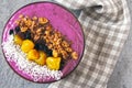 Bright colorful acai bowl with granola and dried fruit.