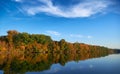 Bright colorful autumn forest landscape, trees near river and blue sky Royalty Free Stock Photo