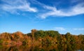 Bright colorful autumn forest landscape, trees near river and blue sky Royalty Free Stock Photo
