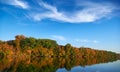 Bright colorful autumn forest landscape, trees near river and blue sky Royalty Free Stock Photo