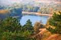 Bright colorful autumn forest landscape, trees near river and blue sky, view from high hill Royalty Free Stock Photo