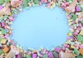 Bright colorful candy on pale blue wood table.
