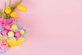 Bright colorful easter background with painted eggs, tulips, cupcake on soft light backdrop, closeup, copy space. Royalty Free Stock Photo