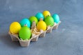 Bright colorful easter eggs in egg carton on grey background Royalty Free Stock Photo