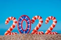 Bright, colorful, funny striped numbers 2022,on sandy beach against blue sky background.Creative Christmas card.Close up Royalty Free Stock Photo