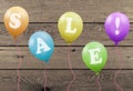 Bright colorful party balloons with text sale on wooden planks board