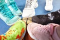 Bright and colorful sport shoes circle with basket ball top view. Set of different sneakers on blue floor, copy space Royalty Free Stock Photo