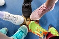 Bright and colorful sport shoes circle with basket ball top view. Set of different sneakers on blue floor, copy space Royalty Free Stock Photo