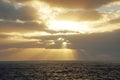 Bright colorful sunrise in the open ocean. Atlantic. The sun`s rays make their way through the clouds. Royalty Free Stock Photo