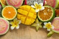 Tropical fruits mango, tangerine, guava, dragon fruit, star fruit, sapodilla with flowers of plumeria on the wooden background. Royalty Free Stock Photo