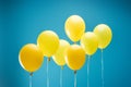 Bright colorful yellow balloons on blue background.